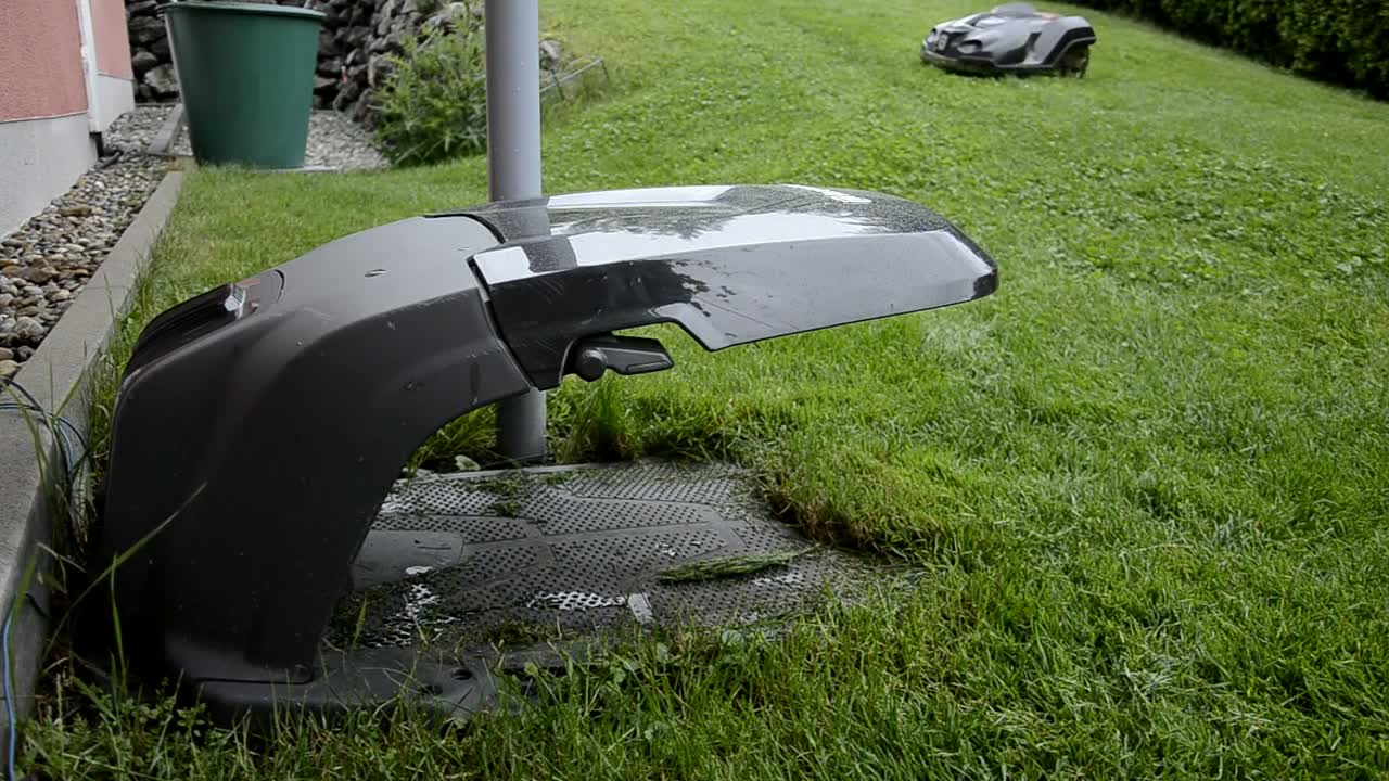Robot lawn mower parked beside a green lawn